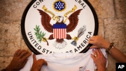 FILE - Palestinian activist place a t-shirt with a logo representing their statehood bid at the UN underneath the US Consulate sign during a small pro-state rally, Wednesday, Sept. 21, 2011 in Jerusalem, Israel. 