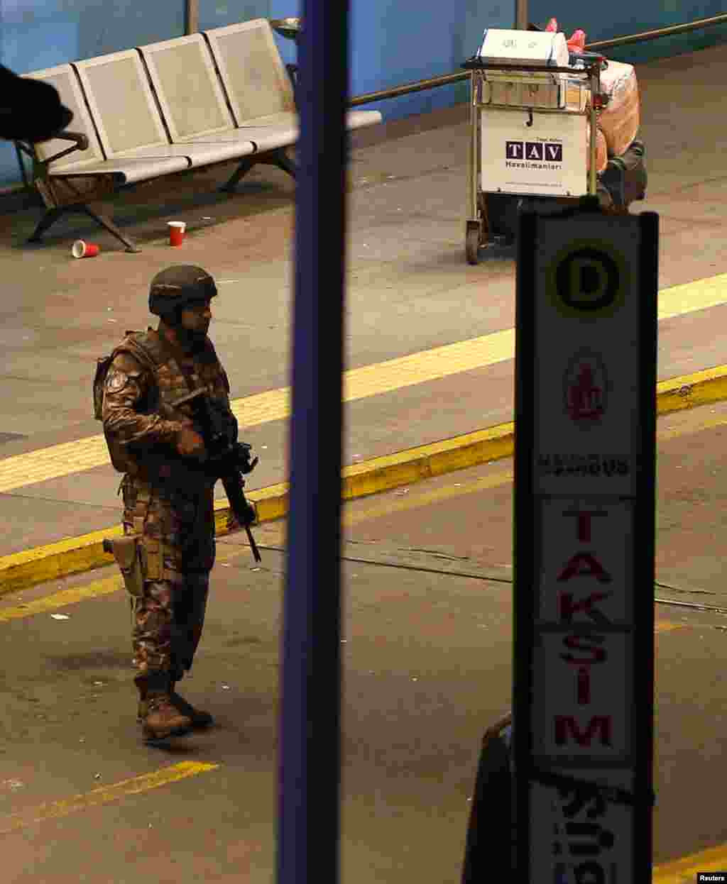 ایک سیکورٹی اہلکار دھماکوں کے بعد پوزیشن لیے کھڑا ہے