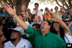 Johnny Araya, presidential candidate for the National Liberation Party, PLN, waves to supporters outside a polling station, after voting in the general election in San Jose, Costa Rica, Feb. 2, 2014.