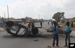 FILE - In this photo taken April 7, 2016, a burnt out vehicle lays on its roof in Lusaka, Zambia. On April 20, 2016, police arrested more than 250 people for alledgedly attacking foreign nationals and looting their stores.