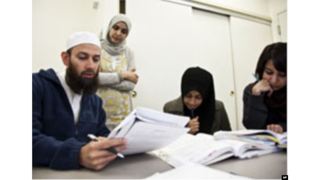 Students (from left to right) Waqas Ahmed, Sifat Reazi and Armaan Siddiqi consult with teacher Souhad Zendah (standing).