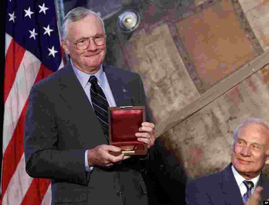 Apollo 11 astronaut, and the first man to walk the moon, Neil Armstrong, left, holds the Langley Gold Medal after it was presented to him by Vice President Al Gore at a ceremony at the Smithsonian Air And Space Museum in Washington, July 20, 1999. 