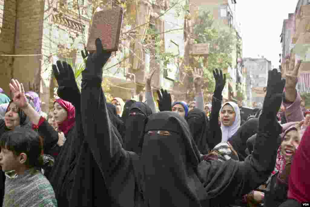 Protesters flash the four finger sign representing Rabaa, which was the location in Cairo that saw the most intense violence six months ago, as they march in Cairo on Feb. 14, 2014. (Hamada Elrasam/VOA) 