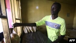 Un Soudanais remet un sac de pain à un client dans une boulangerie de la capitale Khartoum, le 5 janvier 2018. (Photo: AFP / ASHRAF SHAZLY)