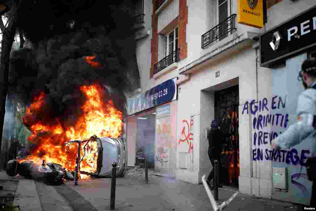 A car burns outside a Renault automobile garage during clashes at the May Day labor union march in Paris, France.
