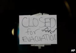 A closed sign is displayed on the door of Papaciito's restaurant due to an evacuation order, Feb. 12, 2017, in Marysville, Calif.