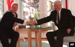 FILE - U.S. President Bill Clinton and Russian President Boris Yeltsin shake hands at the Mantyniemi presidential residence on the outskirts of Helsinki, March 21, 1997, on the second day of their two-day summit.