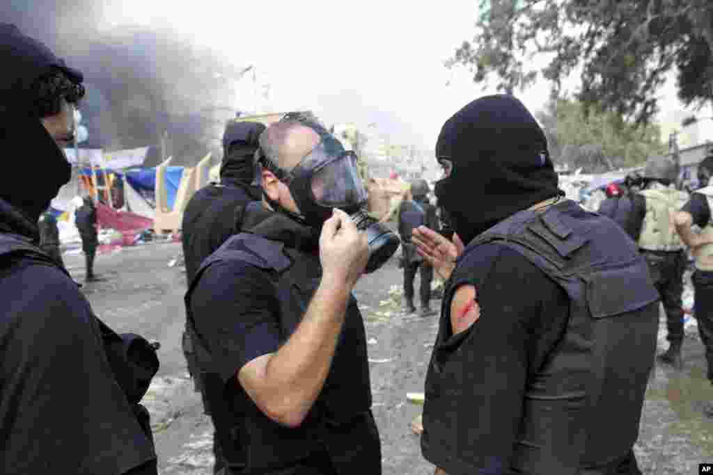 A lightly wounded member of the Egyptian security forces talks with other officers as they clear sit-ins by supporters of ousted Islamist President Mohammed Morsi, near the Cairo University campus in Giza, Cairo, Egypt, August 14, 2013.