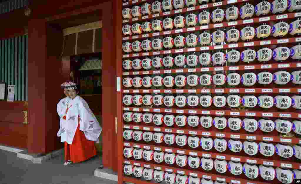 Shinto female attendants come out of the shrine at Kanda Myojin shrine in Tokyo, Japan.