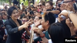 Ousted former Thai Prime Minister Yingluck Shinawatra greets supporters as she leaves the Supreme Court in Bangkok, Thailand, Aug. 1, 2017.