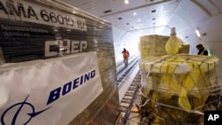 FILE - Workers move cargo into position inside a new AirBridgeCargo Boeing 787-8 freighter airplane, Oct. 7, 2016, at Seattle-Tacoma International Airport.