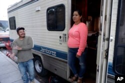 Delmi Ruiz, right, and her husband Benito Hernandez chat outside their RV where their family lives and sleeps, Oct. 5, 2017, in Mountain View, California.