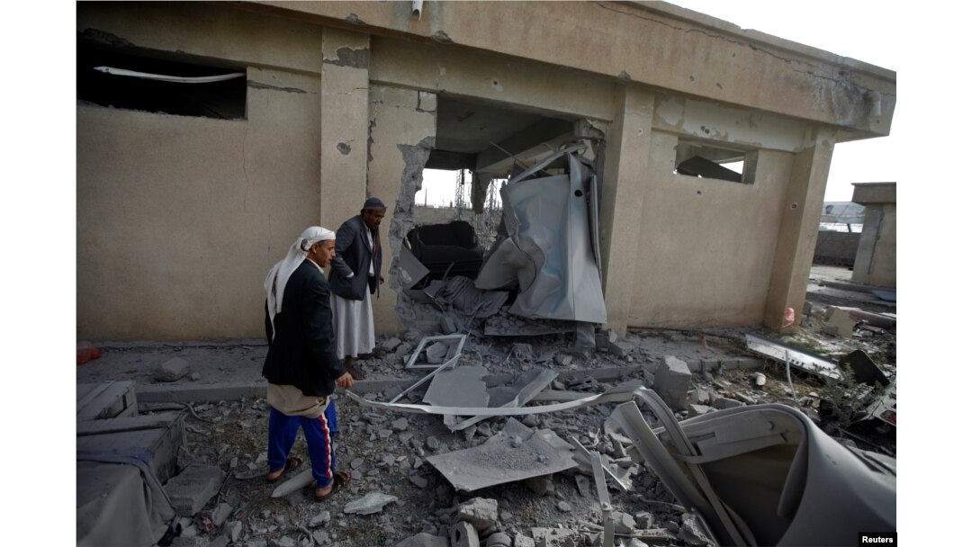 FILE - Men inspect the site of an airstrike in Sanaa, Yemen, April 20, 2018.