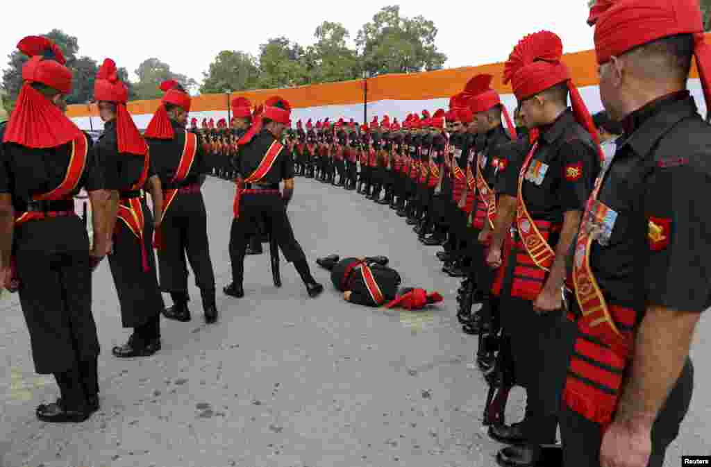 An Indian Army soldier faints during a ceremony to commemorate the 50th anniversary of a war between India and Pakistan, at the India Gate war memorial in New Delhi.