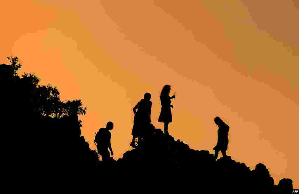 People look at the horizon soon after sunrise from the rocky crest filled with astronomical markers at the megalithic observatory of Kokino, Macedonia, during the summer solstice. The ancient astronomic observatory, located about 100 kms northeast of Skopje, dates back to more than 4,000 years ago.