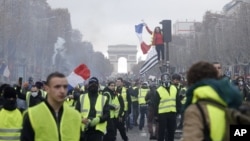 Los manifestantes marchan en la famosa avenida Campos Elíseos, en París, Francia, mientras protestan por el alza de los precios del combustible el 24 de noviembre de 2018.