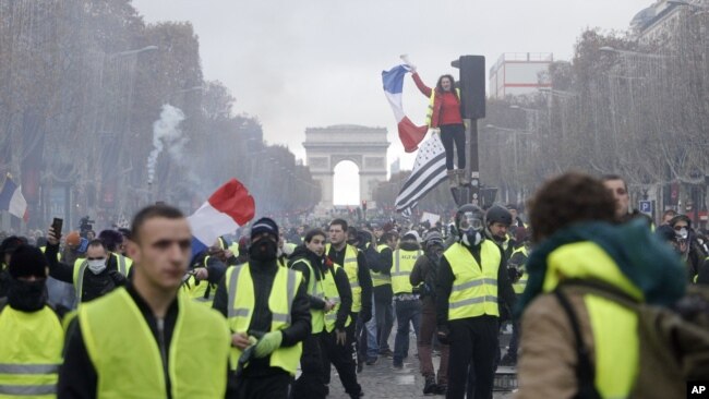 Los manifestantes marchan en la famosa avenida Campos Elíseos, en París, Francia, mientras protestan por el alza de los precios del combustible el 24 de noviembre de 2018.