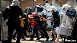 Riot police beat protesters during a demonstration to blame the ruling AK Party government on mining disaster in Izmir, western Turkey, May 15, 2014.