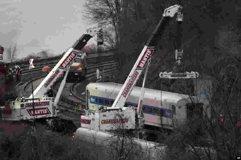 Cranes lift a derailed Metro-North train car in the Bronx borough of New York, Dec. 2, 2013. 