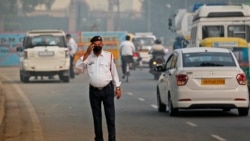 A Delhi Traffic police officer wears a pollution mask and clears the irritants in his eyes in New Delhi, India, Monday, Nov. 4, 2019. (AP Photo/Manish Swarup)