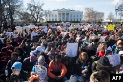 Thousands of local students sit for 17 minutes in honor of the 17 students killed last month in a high school shooting in Florida, during a nationwide student walkout for gun control in front the White House in Washington, March 14, 2018.
