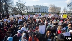 Thousands of local students sit for 17 minutes in honor of the 17 students killed last month in a high school shooting in Florida, during a nationwide student walkout for gun control in front the White House in Washington, DC, March 14, 2018. (AFP Photo)