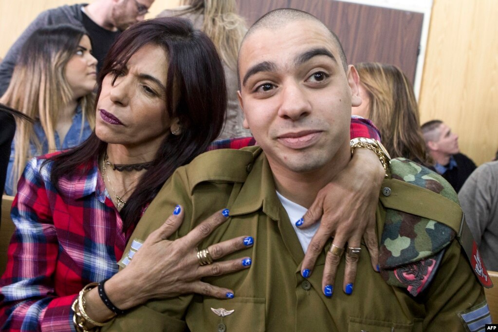 지난해 3월 쓰러진 팔레스타인 주민을 조준 사살한 혐의로 텔아비브 군사법정에 선 이스라엘군 병사 엘로르 아자리아(오른쪽)를 어머니가 감싸안고 있다. 군사법원은 아자리아에게 징역 18개월을 선고했다.