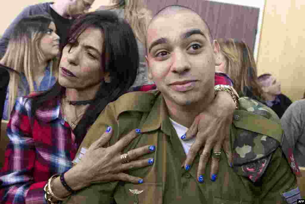 Israeli soldier Elor Azaria (R), who shot dead a wounded Palestinian assailant in March 2016, is embraced by his mother Oshra (L) at the start of his sentencing hearing in a military court in Tel Aviv.