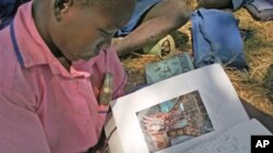 A Ugandan student reads a letter from her American pen pal.