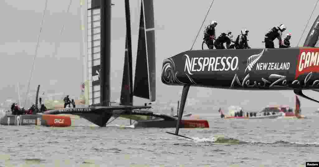 Emirates Team New Zealand (R) sails ahead of Oracle Team USA during Race 13 of the 34th America&#39;s Cup yacht sailing race in San Francisco, California, Sept. 20, 2013.