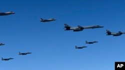 In this photo provided by South Korea Defense Ministry, U.S. Air Force B-1B bombers, F-35B stealth fighter jets and South Korean F-15K fighter jets fly over the Korean Peninsula during a joint drill on Sept. 18, 2017.