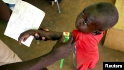 FILE - A Congolese boy has his arm measured for malnutrition in a clinic run by medical charity Medecins Sans Frontieres in the remote town of Dubie in Congo's southeastern Katanga province, March 18, 2006. 