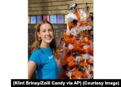 Here, Alina Morse stands next to her creation, a decorated tree for Halloween. (Klint Briney/Zolli Candy via AP)