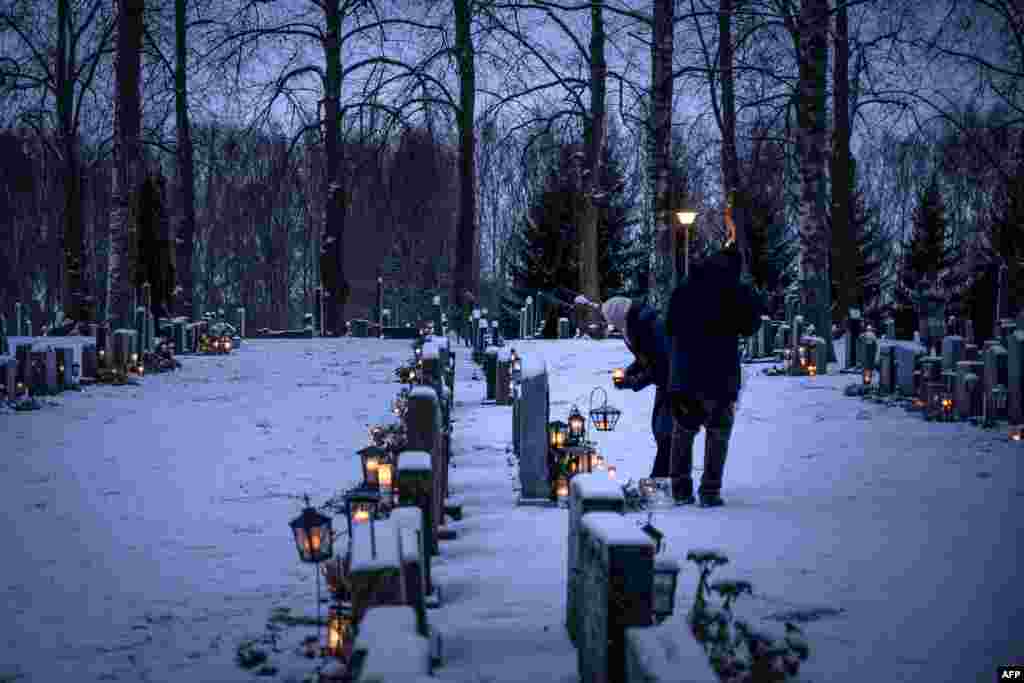 핀란드 서부 바사의 묘지에서 시민들이 비석 앞에 등불을 놓고 있다.