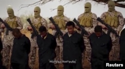 FILE - Militants from the so-called Islamic State stand behind what are said to be Ethiopian Christians in Libya, in this still image from an undated video posted to a social media website on April 19, 2015.