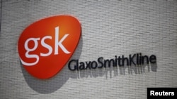 FILE - The logo of GlaxoSmithKline (GSK) is seen on its office building in Shanghai.