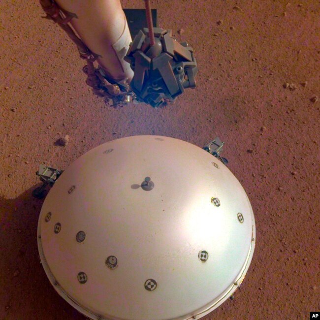 This photo made available by NASA on Tuesday, April 23, 2019 shows the Mars InSight lander's domed wind and thermal shield which covers a seismometer. (NASA/JPL-Caltech via AP)