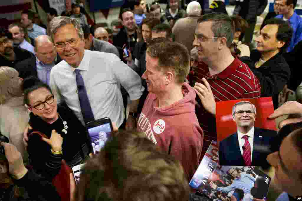 A man holds a photograph of Republican presidential candidate Jeb Bush as Bush greets people after a campaign event in Salem, New Hampshire, Feb. 7, 2016.