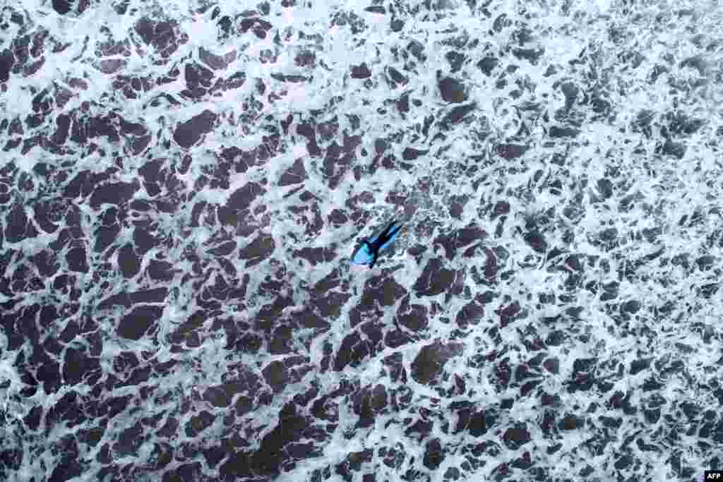 An aerial view shows a surfer paddling out during a free surf session in Flackstad, Northern Norway, on the eve of the Lofoten Masters 2018.