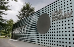 FILE - The logos of Gannett Co and its flagship newspaper, USA Today, are seen outside their corporate headquarters in McLean, Virginia, July 23, 2013.