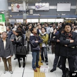 Train passengers wait at Tokyo's Shinagawa station to get first-hand information on train service, which was halted following a very strong earthquake on March 11, 2011