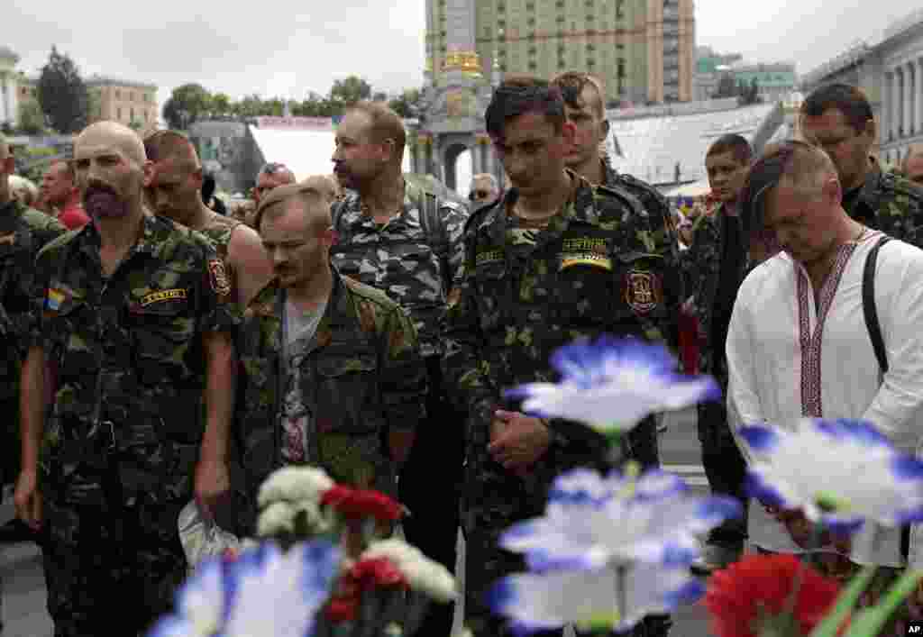 Members of self-defense units stand during a minute of silence in honor of people killed in Independence Square during clashes February 18-21 in Kyiv and soldiers killed during anti-terrorist campaigns in the east of Ukraine, Independence Square, Kyiv, June 2, 2014.