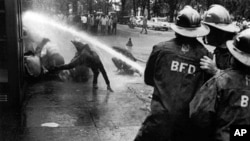 FILE - In this July 15, 1963 file photo, firefighters aim their hoses on civil rights demonstrators in Birmingham, Ala.