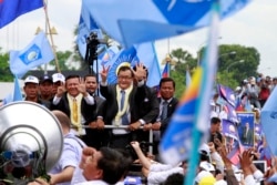 FILE: Sam Rainsy, center, president of Cambodia National Rescue Party (CNRP) greets his supporters together with his party's Vice President Kem Sokha, on Rainsy's left, on his arrival at Phnom Penh International Airport in Phnom Penh, Cambodia, Friday, July 19, 2013.