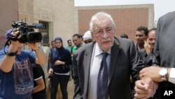 FILE - Egyptian actor Gamil Ratib is helped by a relative as he attends Omar Sharif's burial at the El Shafie Cemetery in Cairo, Egypt, Sunday, July 12, 2015. 