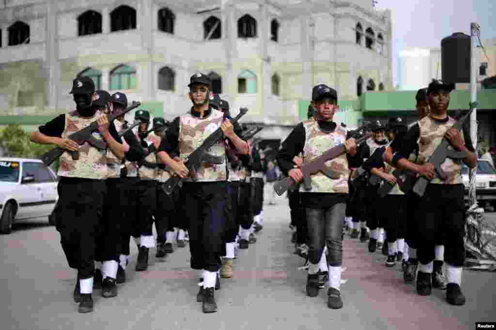 Học sinh người Palestine cầm vũ khí bằng gỗ tham gia vào một buổi biểu diễn kiểu quân sự tại một trường học ở thành phố Rafah, phía nam Dải Gaza.