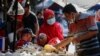 Seorang perempuan mengenakan masker untuk mencegah penularan COVID-19 sedang berbelanja di sebuah pasar tradisional di Jakarta, 1 Maret 2021. (Foto: Willy Kurniawan/Reuters) 