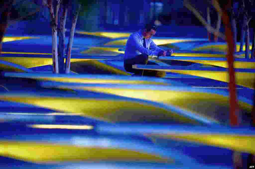 An unidentified man takes photos before sunrise at the National 9/11 Pentagon Memorial, Sept. 11, 2015, on the 14th anniversary of the 911 attacks. 
