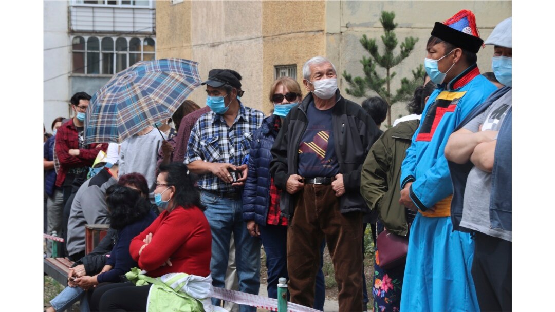 Warga mengenakan masker, antri untuk memberikan suara mereka di luar tempat pemungutan suara No.23-9 di distrik Bayanzurkh Ulaanbaatar, Mongolia, Rabu, 24 Juni 2020.