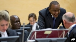 Kenya President Uhuru Kenyatta, second right, talks to his defense team when appearing before the International Criminal Court in The Hague, Netherlands, Oct. 8, 2014.